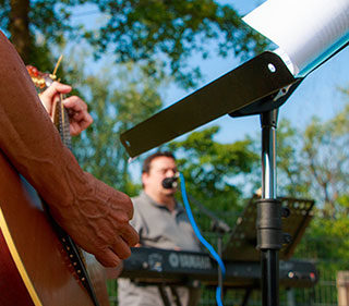 gig with guitar player in front of keyboard player with microphone