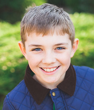 smiling young boy who is happy that he is taking piano lessons