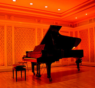 grand piano in a hall with red lights