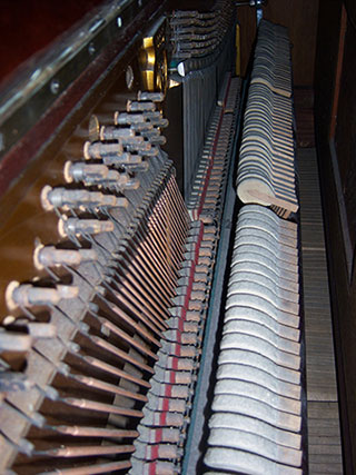 inside of a piano with close up view of strings and hammers