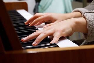 close up of student taking a piano lesson