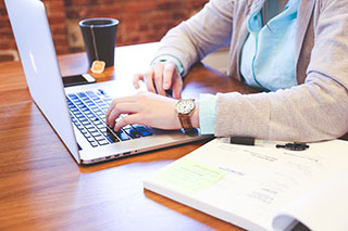 person sitting at a table with a laptop